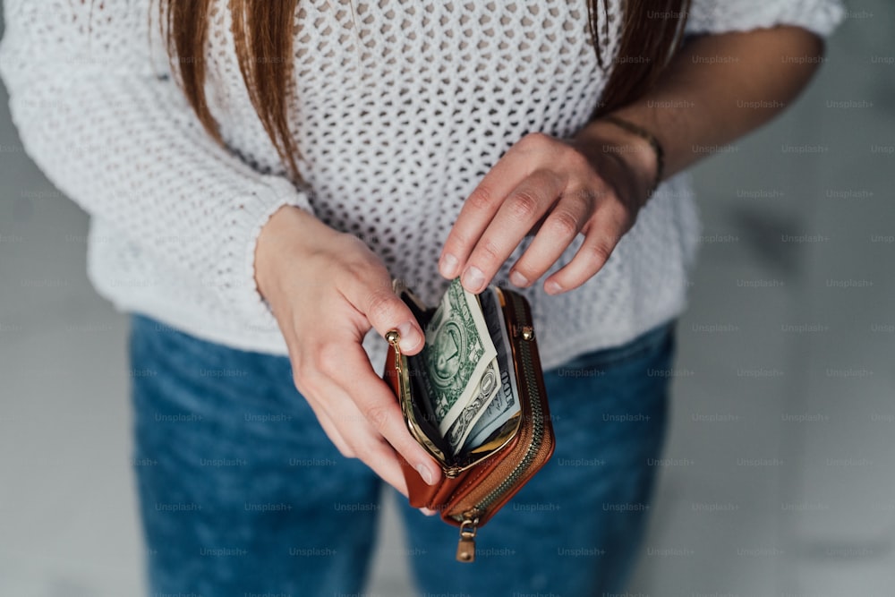 a woman is holding a wallet and money