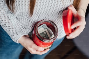 a woman holding a red cup with money in it