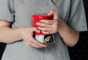 a woman holding a red cup filled with money