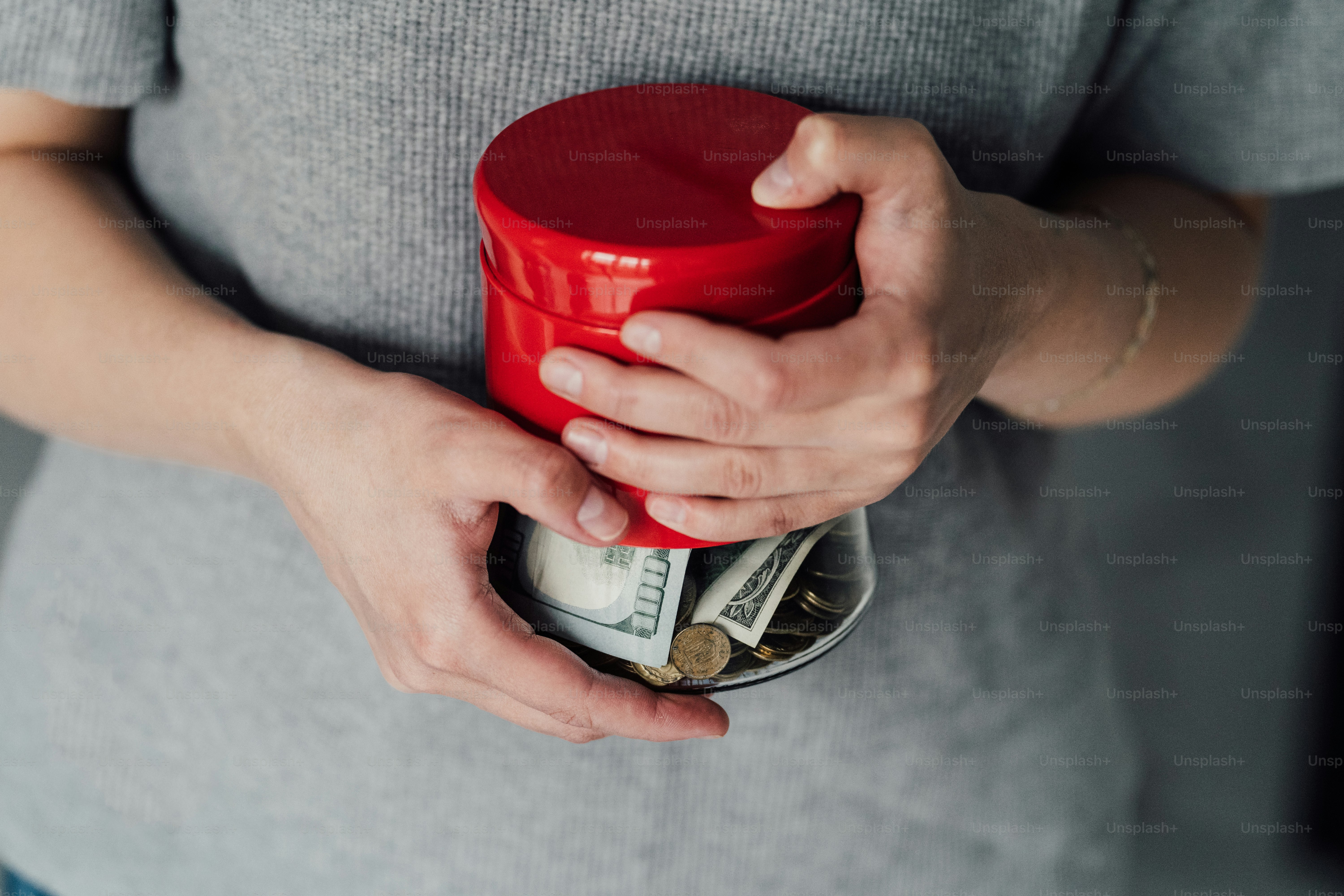 a woman holding a red cup with money in it