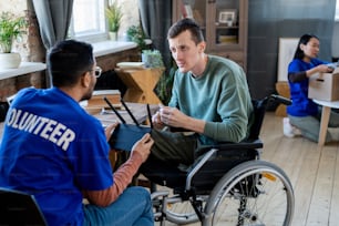 Two young men talking while one of them sitting in a wheelchair