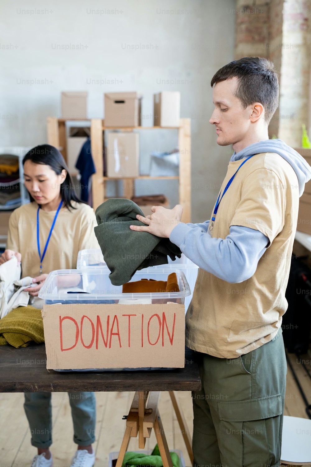 Young man and woman choosing donation clothes