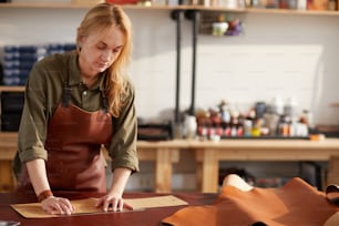 Porträt einer Kunsthandwerkerin, die in der Werkstatt mit Leder arbeitet, Kopierraum
