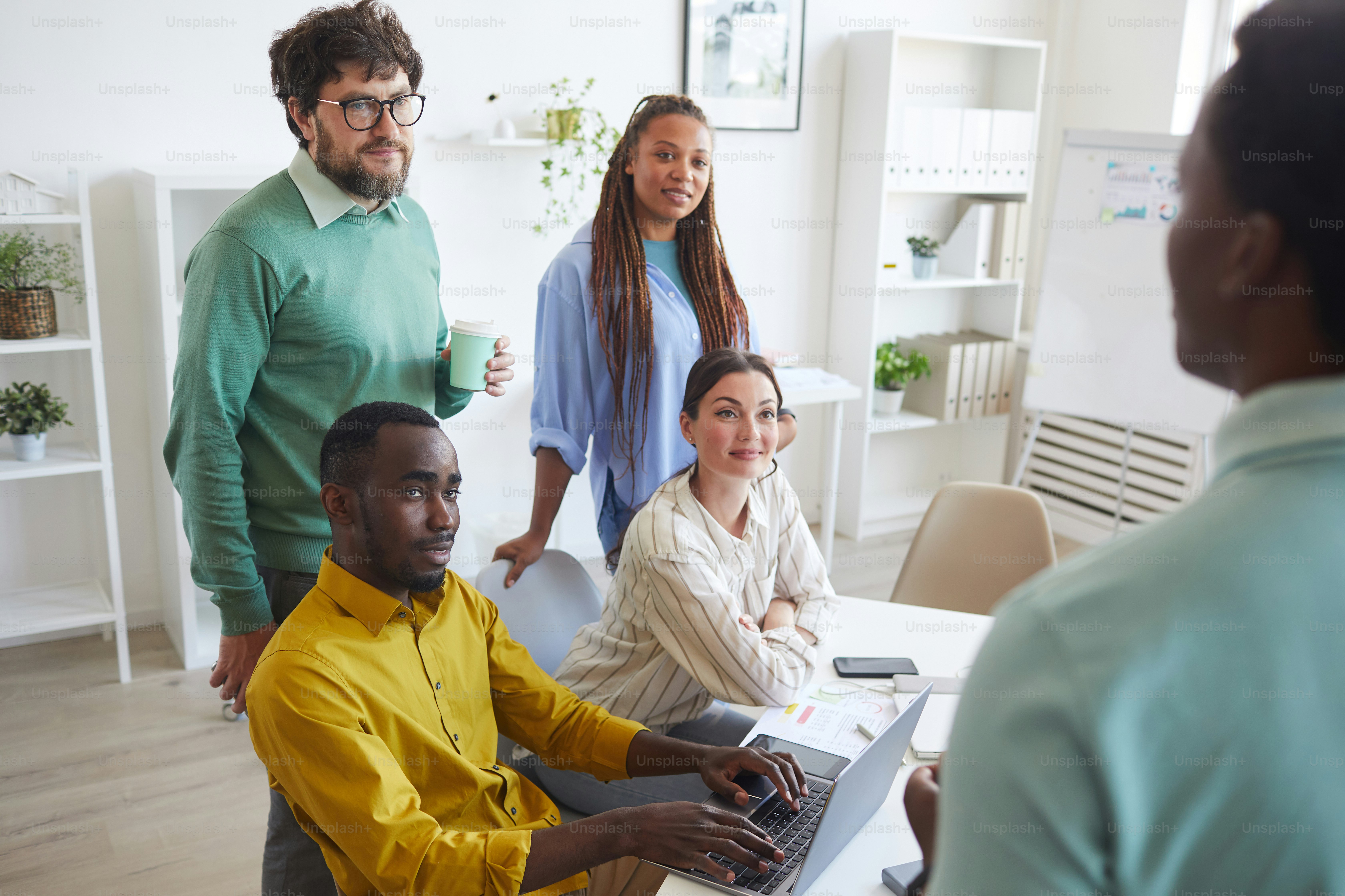 Visão de alto ângulo na equipe de negócios multiétnica ouvindo o colega enquanto compartilha ideias durante a reunião no escritório, espaço de cópia