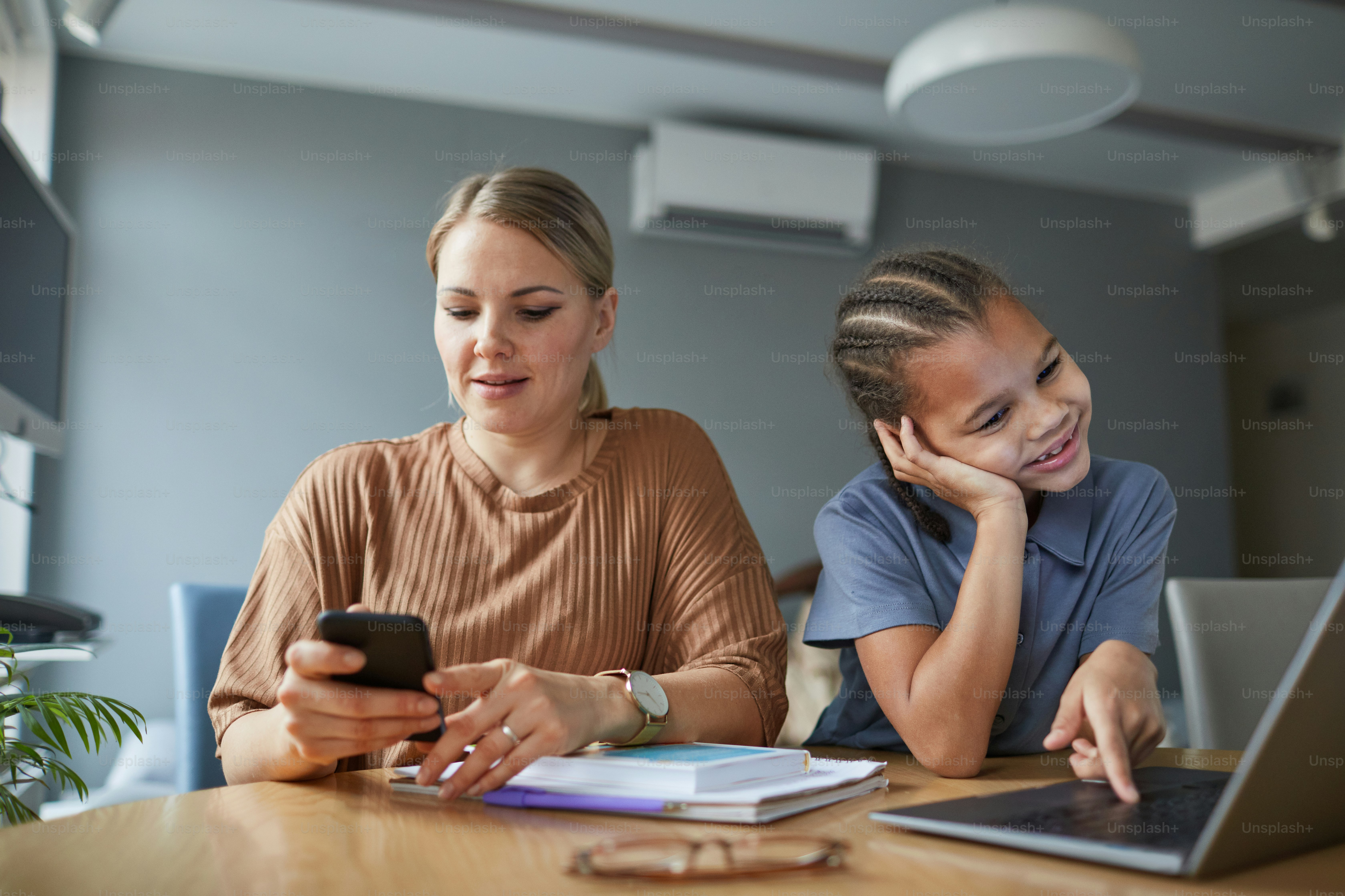 Portrait of multiethnic family, happy mother and daughter using laptop screen together at home, copy space