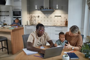 Portrait of multiethnic family with two children in casual home scene, copy space