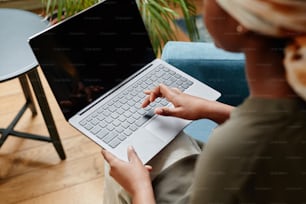 High angle view at young African-American woman working at home and using laptop, copy space