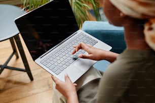 Vista de ángulo alto en una joven afroamericana que trabaja en casa y usa una computadora portátil, espacio de copia