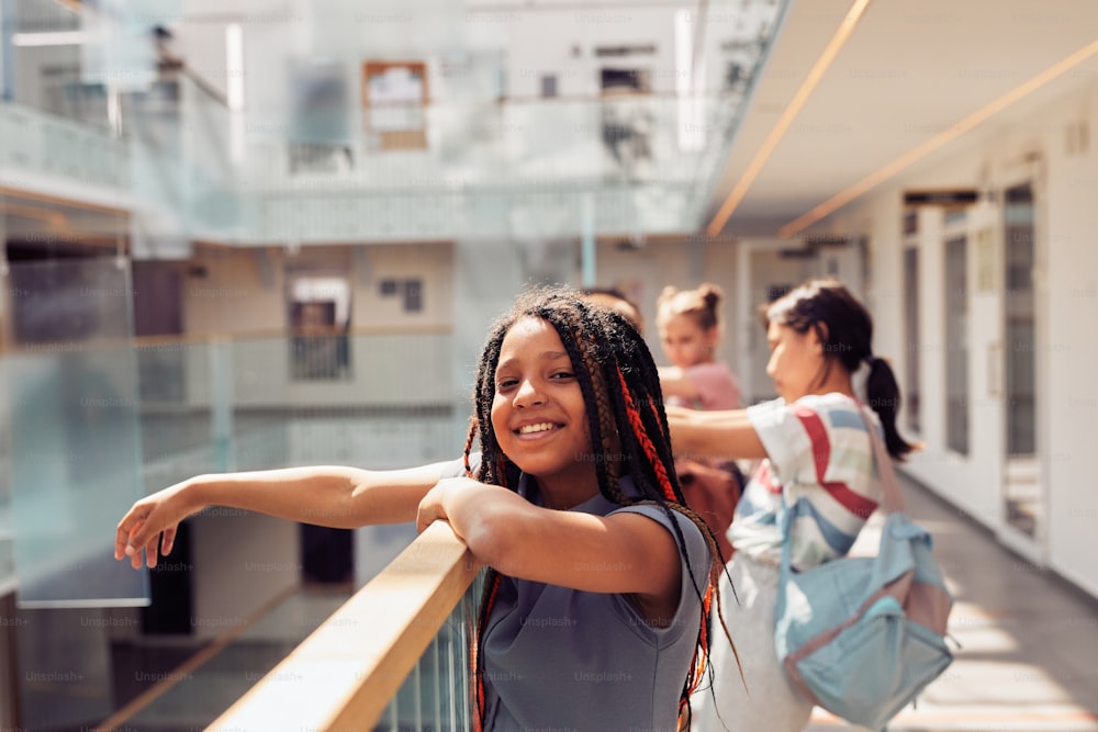 Porträt eines lächelnden afroamerikanischen Mädchens, das den ersten Schultag genießt und in die Kamera schaut, während es im Sonnenlicht steht, Kopierraum