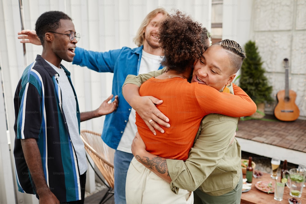 Diverse group of modern young friends greeting each other at rooftop party, copy space
