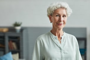 Portrait of smiling senior woman looking at camera in retirement home, copy space