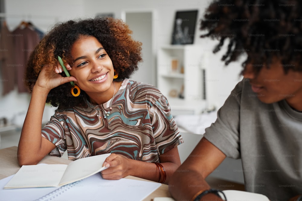 Portrait of two African-American teenagers studying together at home, copy space