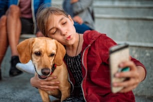Menina e seu pequeno cão amarelo tirando selfie