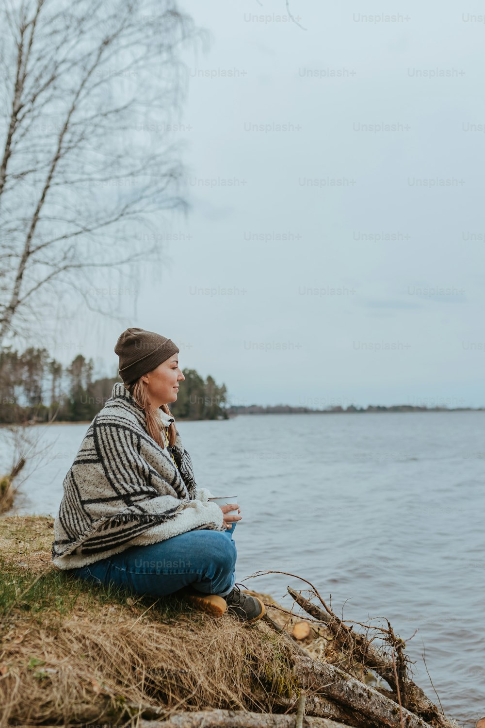 Eine Frau, die am Ufer eines Sees sitzt