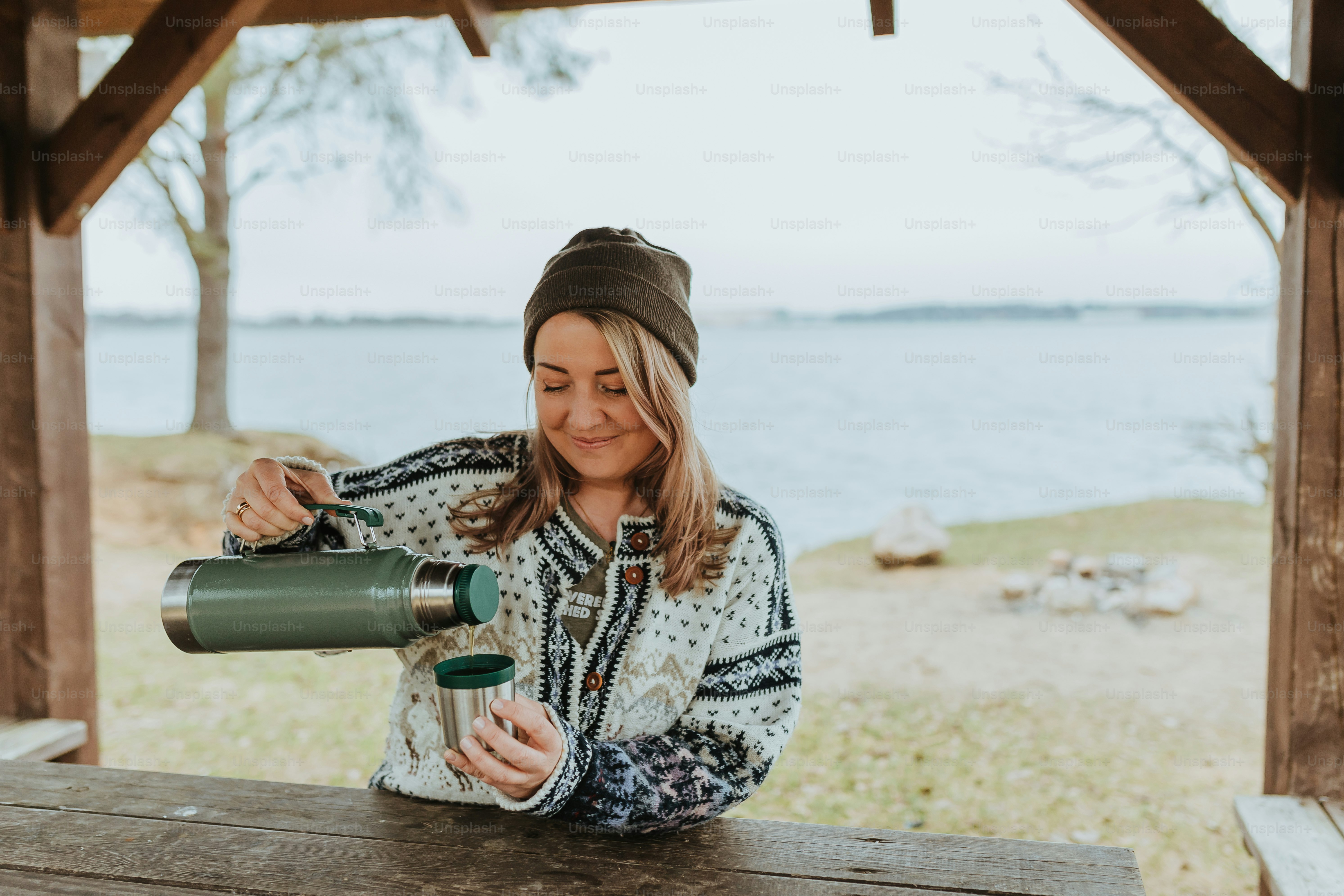 uma mulher sentada em uma mesa de piquenique olhando através de uma lente binoculares