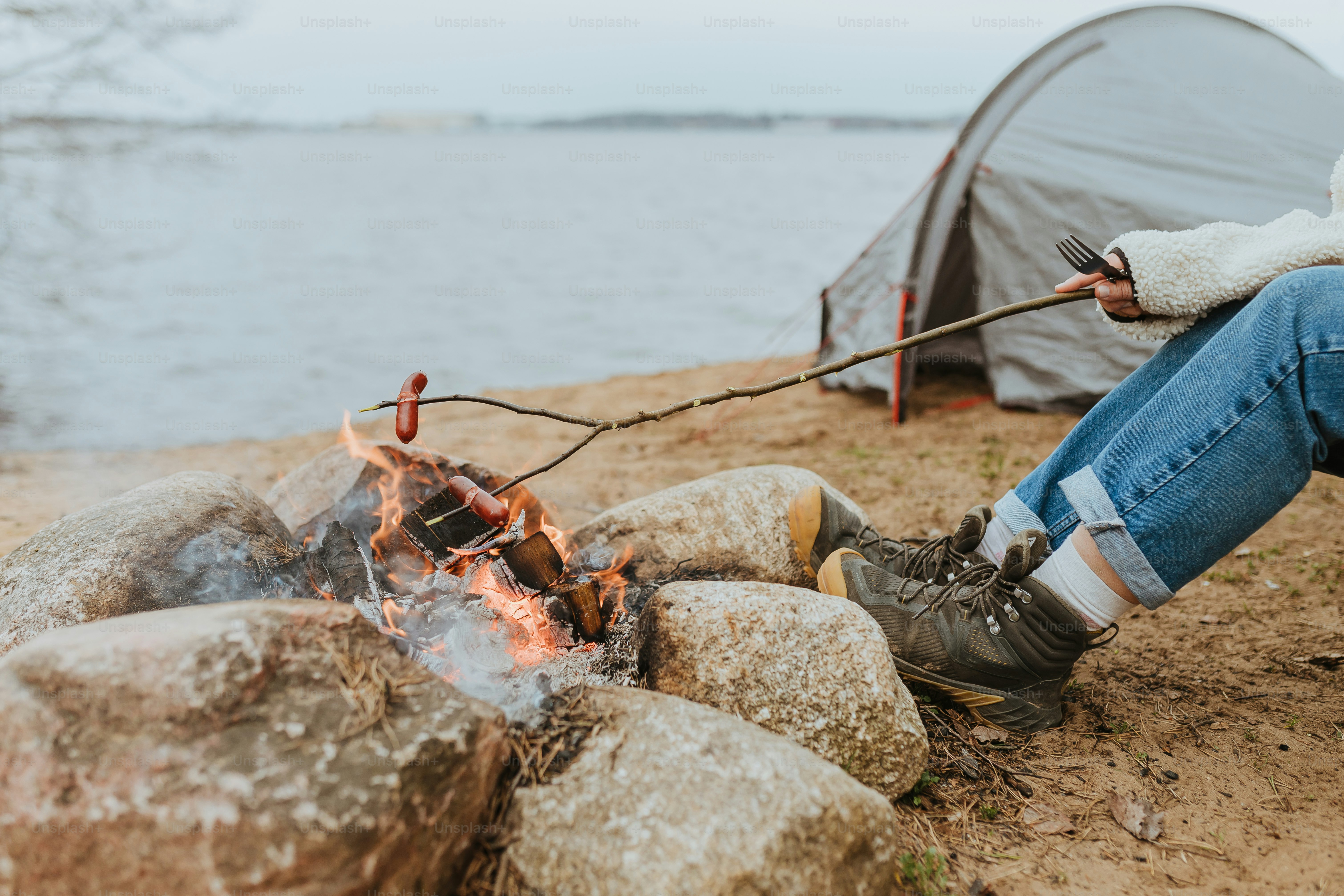 a person sitting next to a camp fire