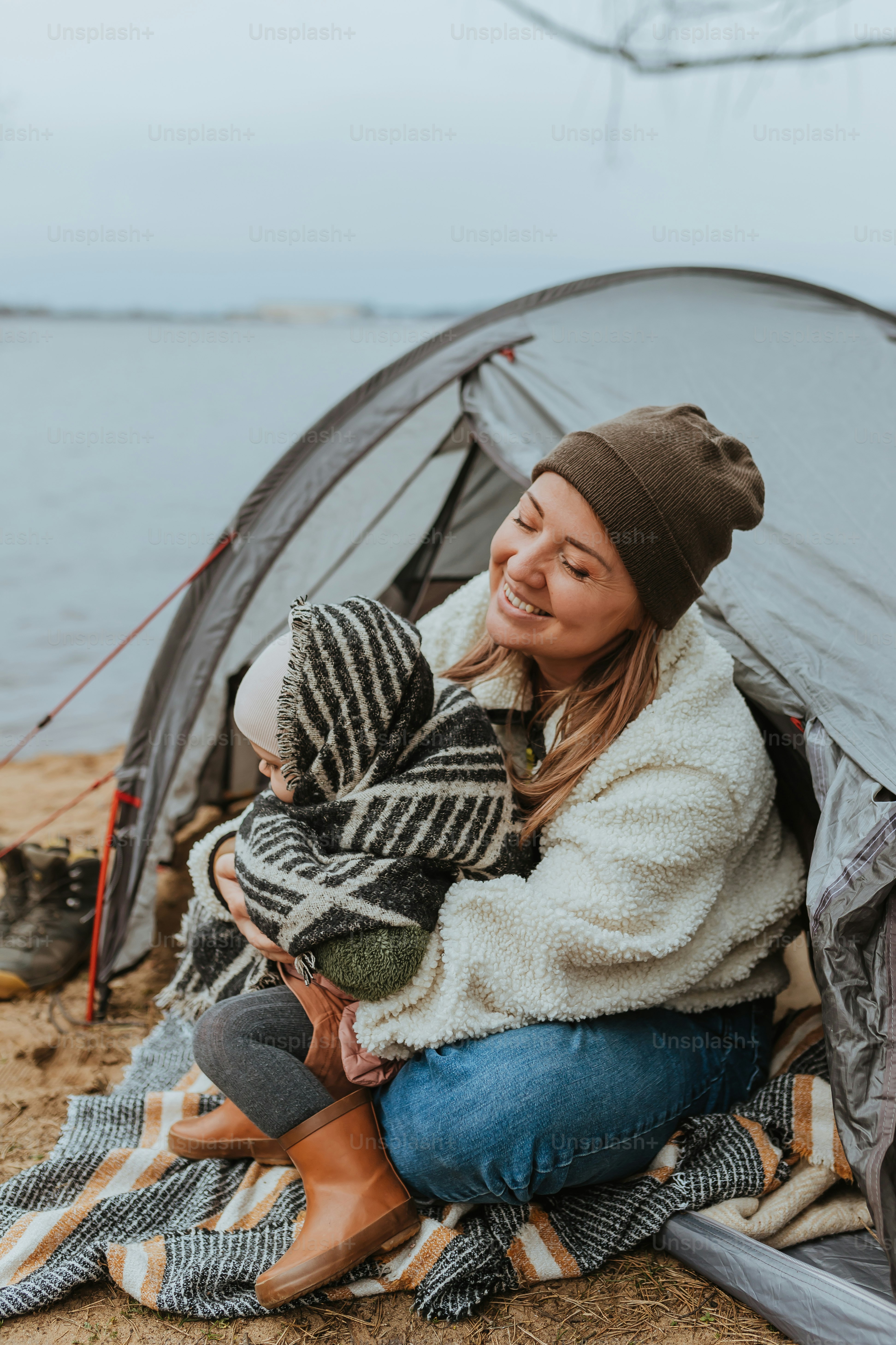 a woman sitting in a tent with a child