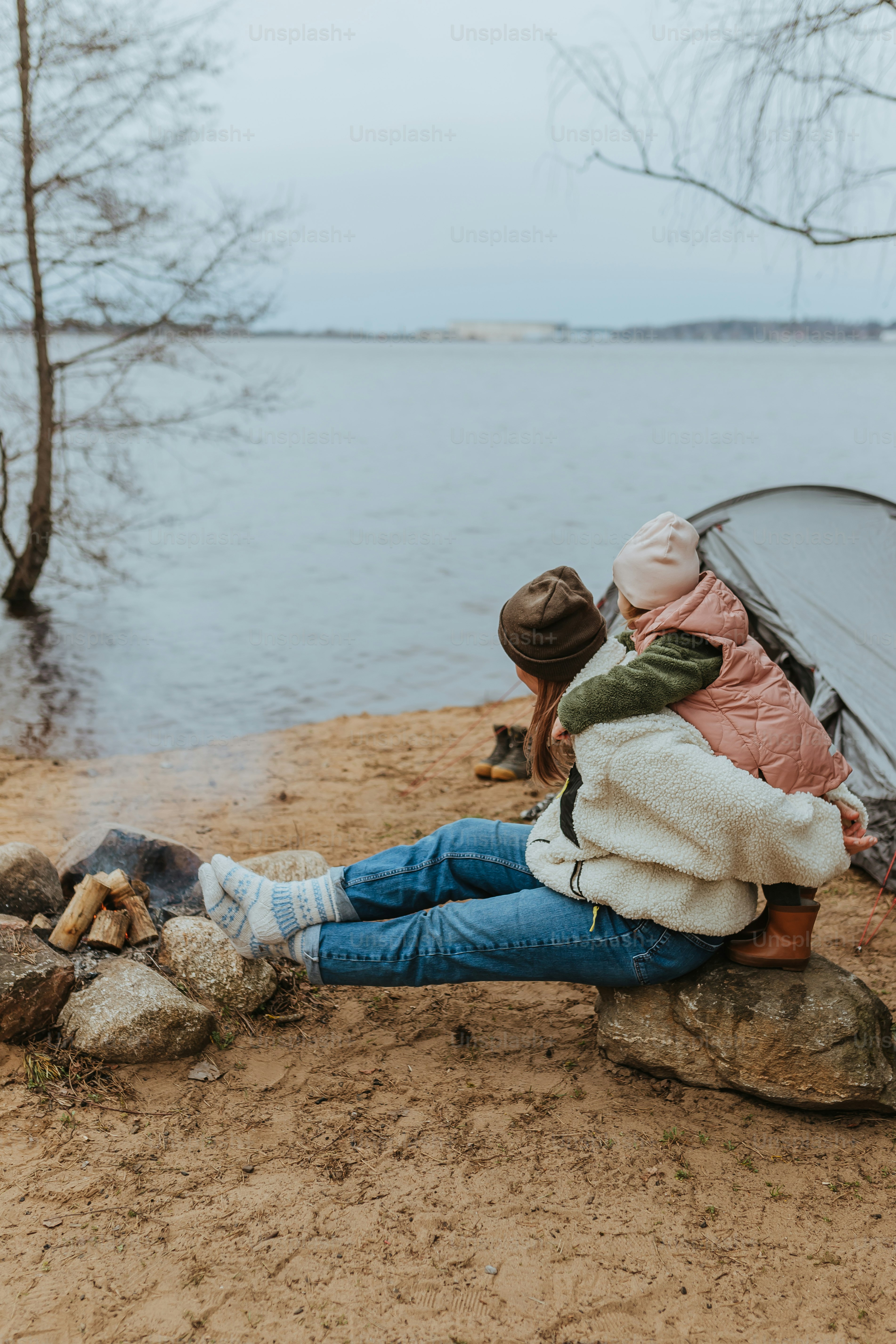 una donna seduta su una roccia accanto a una tenda