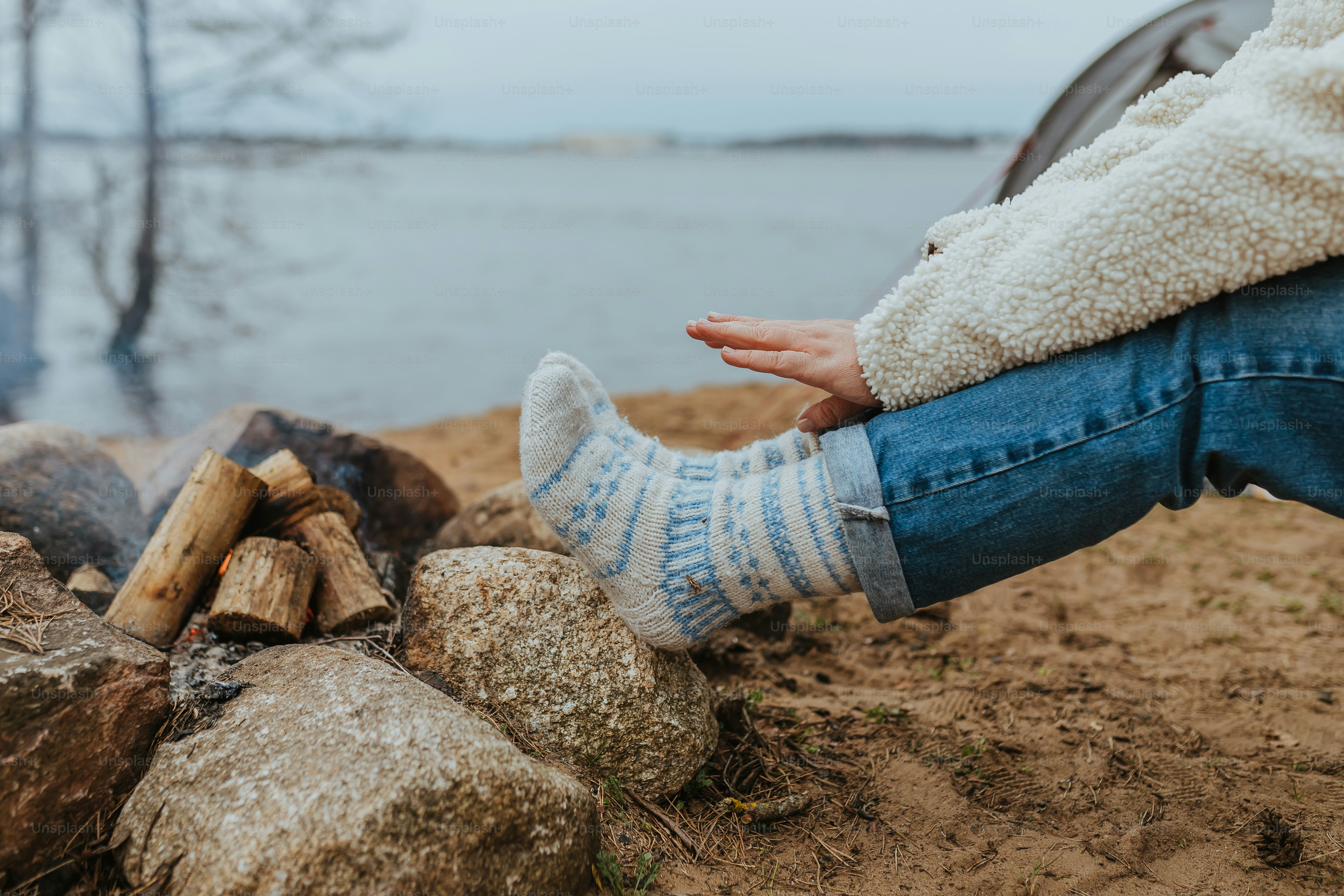 a person sitting next to a pile of logs