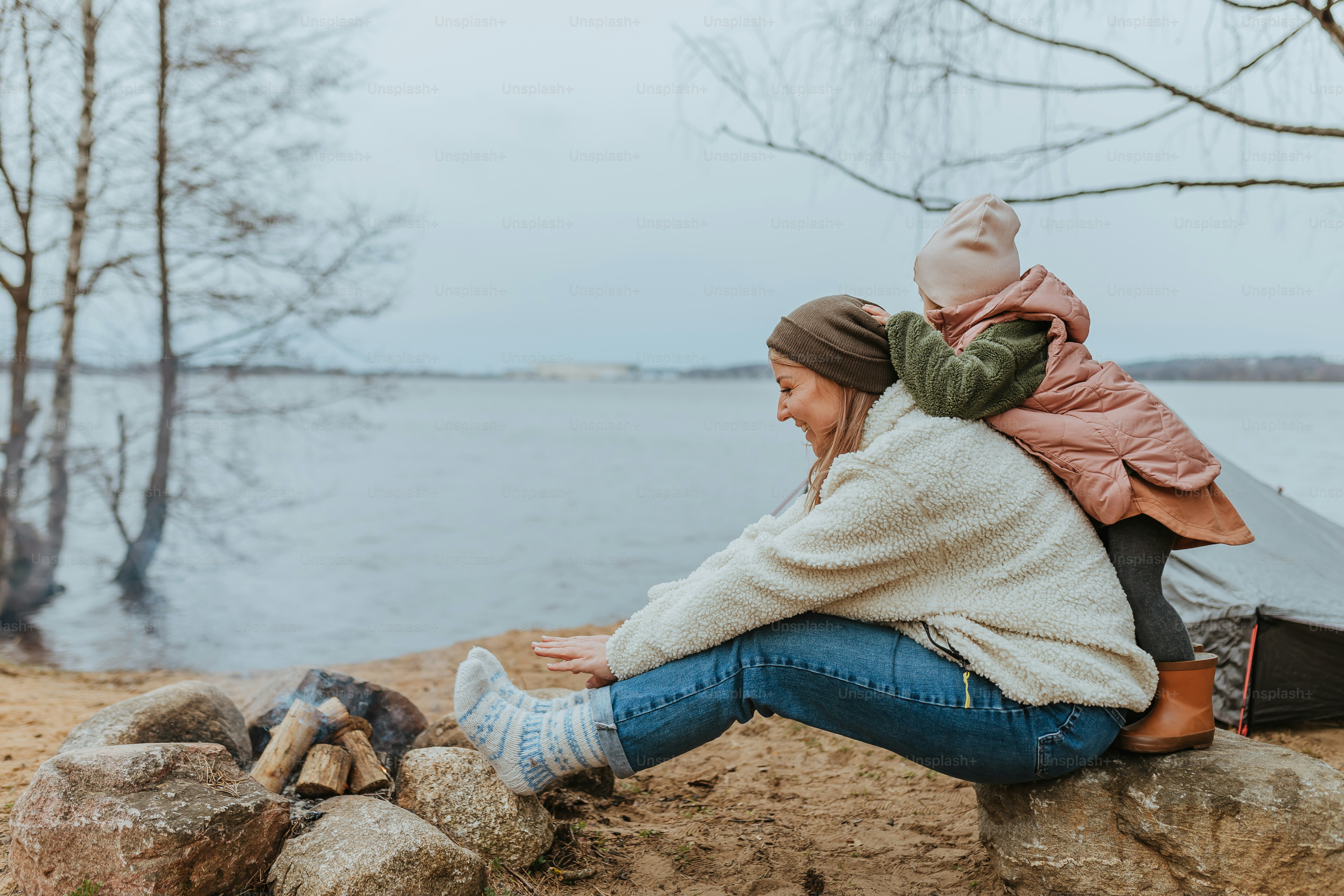 a woman sitting on a rock next to a lake
