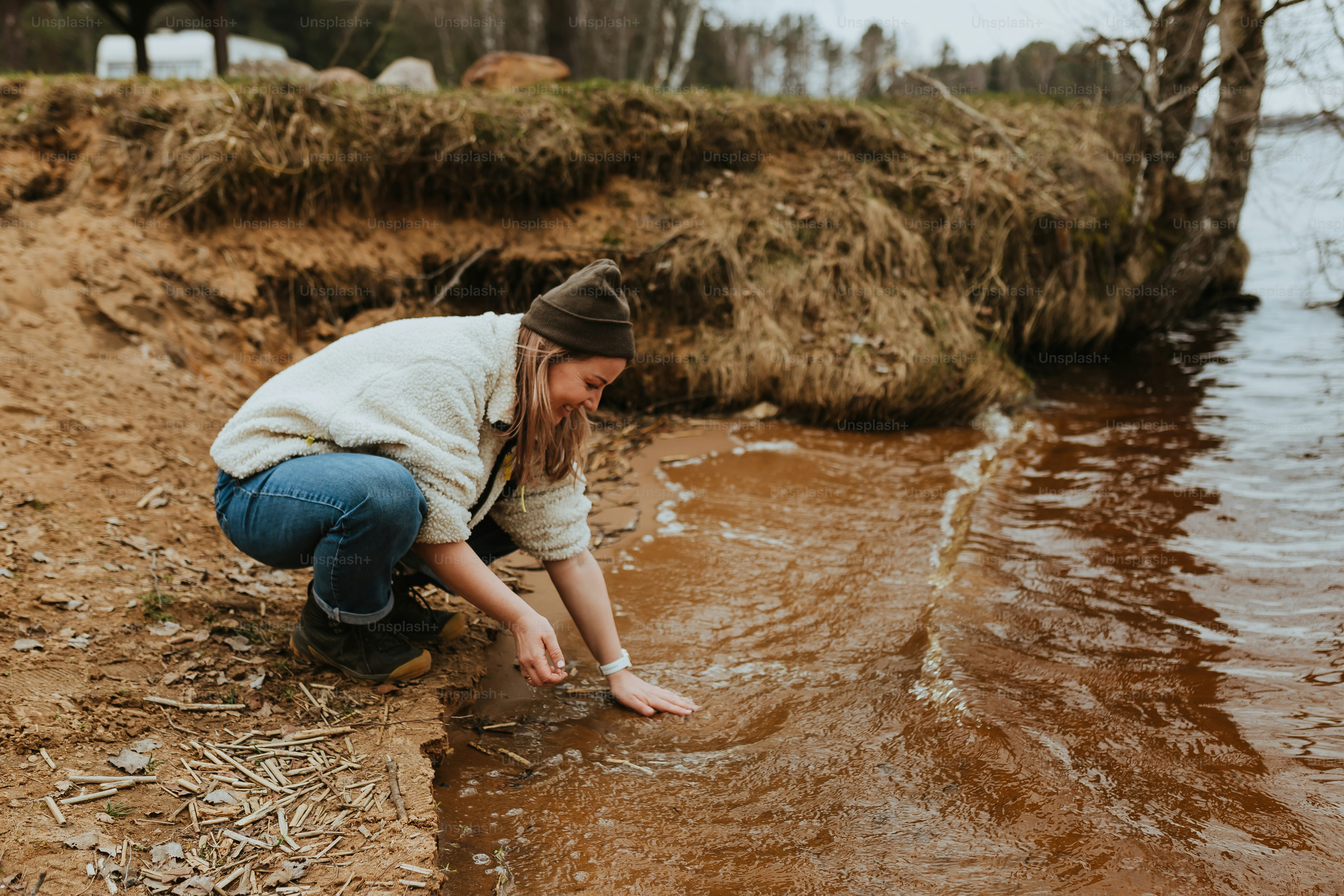 a woman kneeling down to pick up a fish