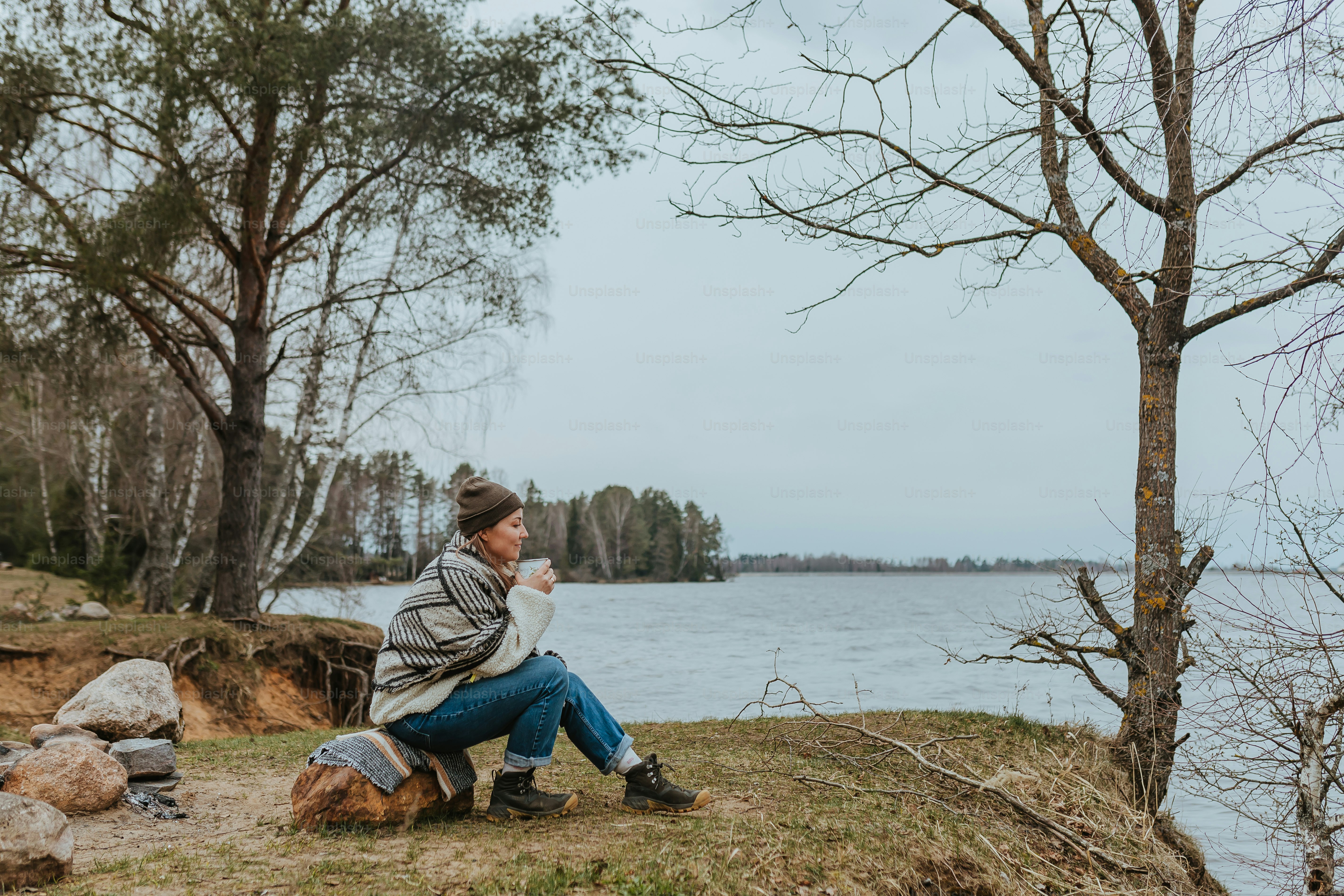 Un homme assis sur une colline à côté d’un plan d’eau