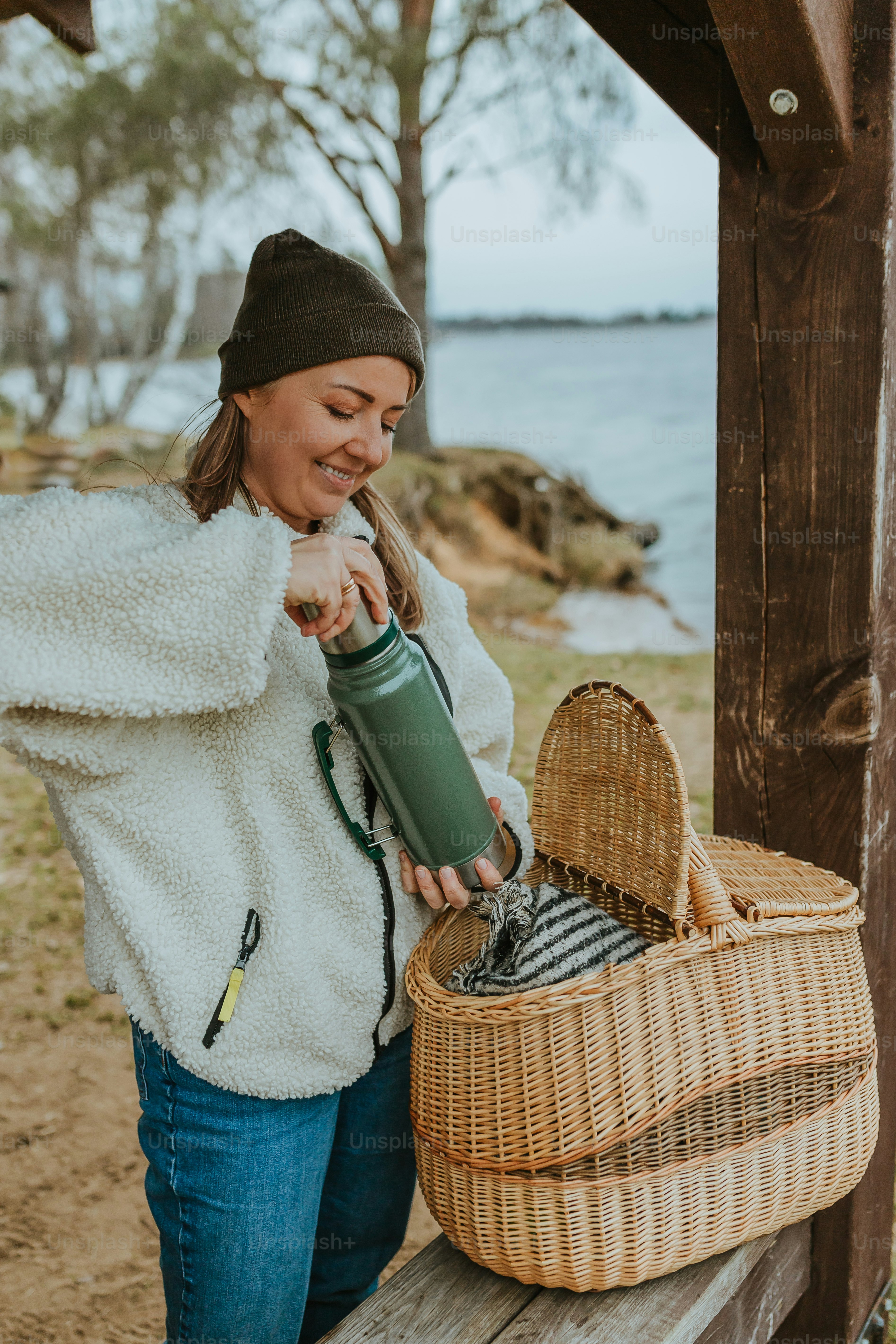 a woman standing next to a basket holding a water bottle