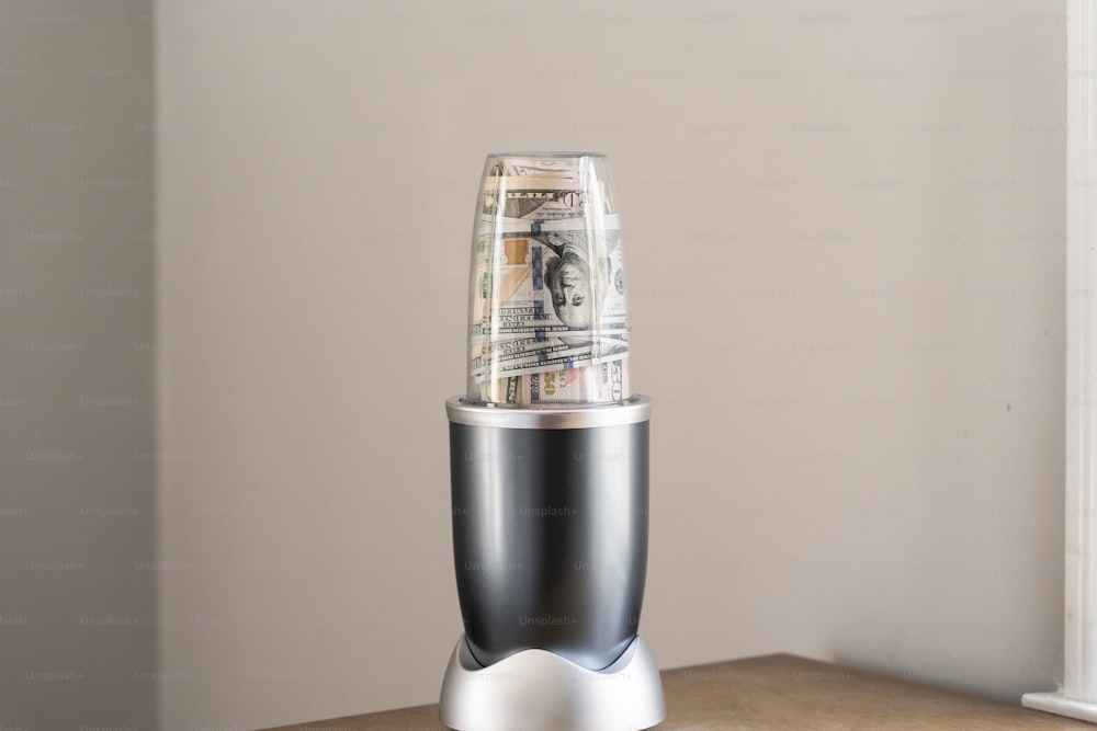 a silver and black blender sitting on top of a wooden table