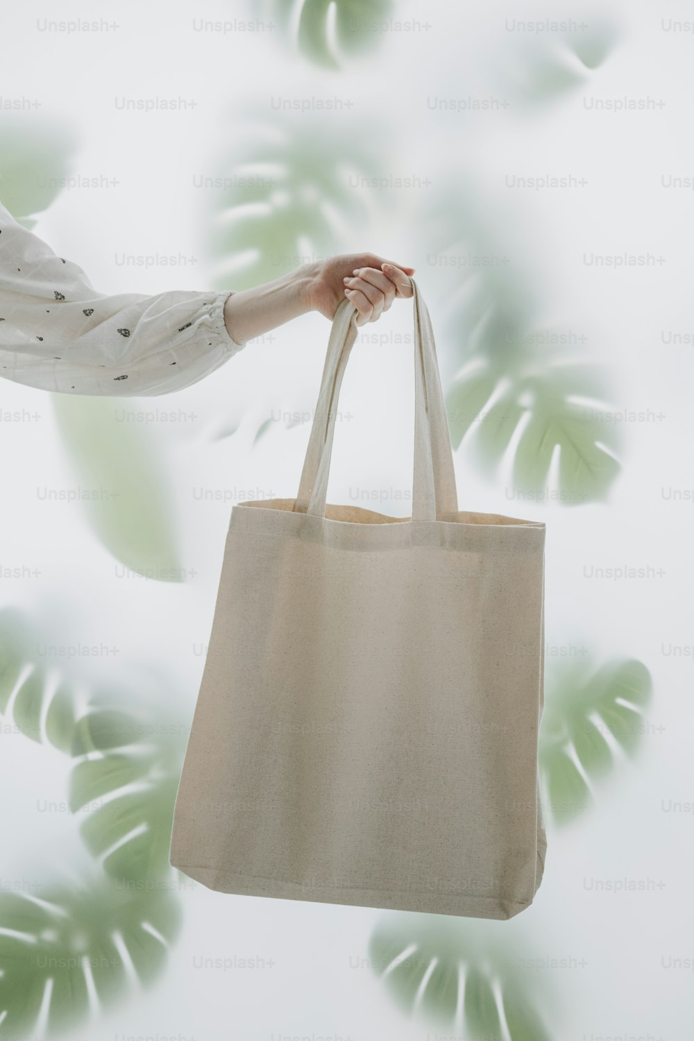 a person holding a bag in front of a plant