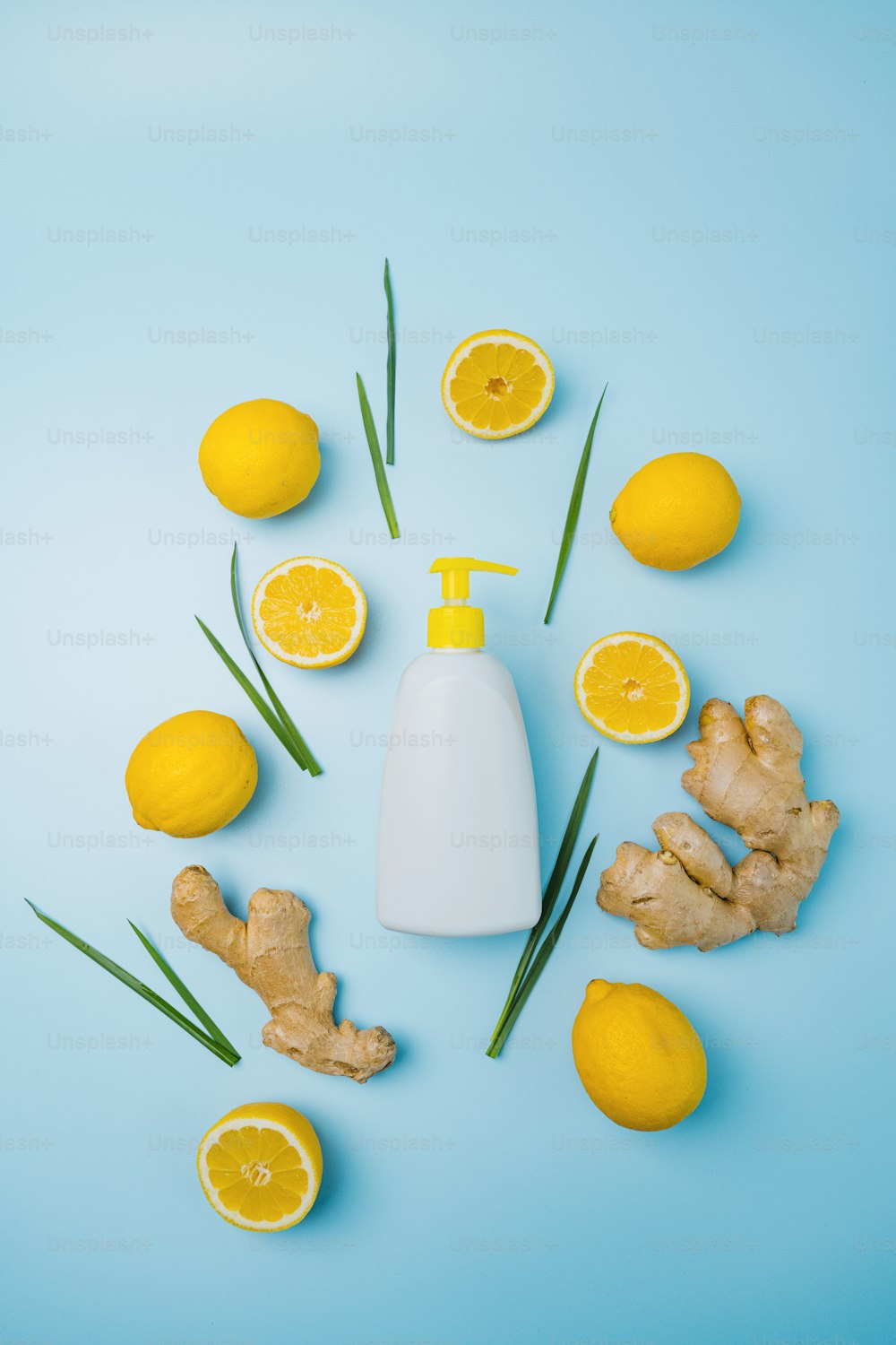 eine Flasche Lotion, umgeben von Zitronen und Ingwer