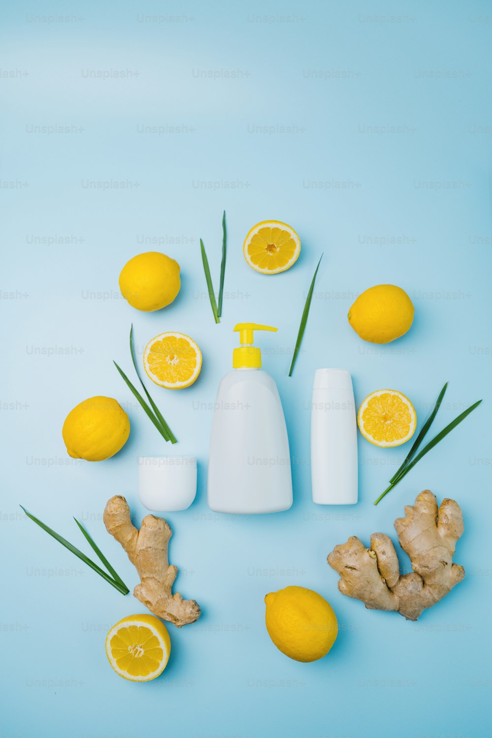 eine Flasche Lotion, umgeben von Zitronen und Ingwer