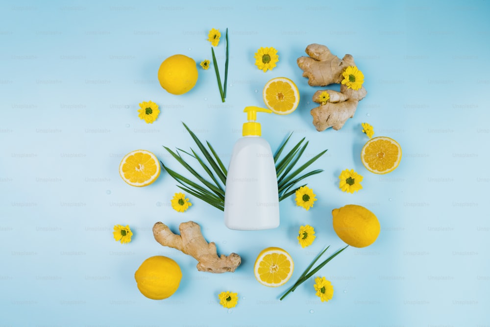 a bottle of lotion surrounded by lemons and ginger