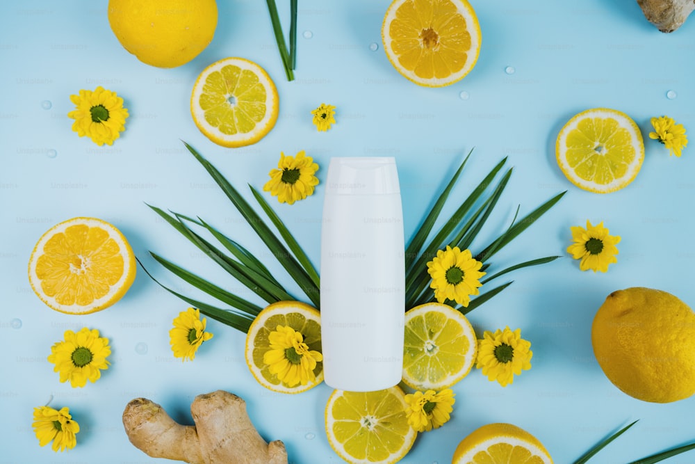 a bottle of lotion surrounded by lemons and ginger