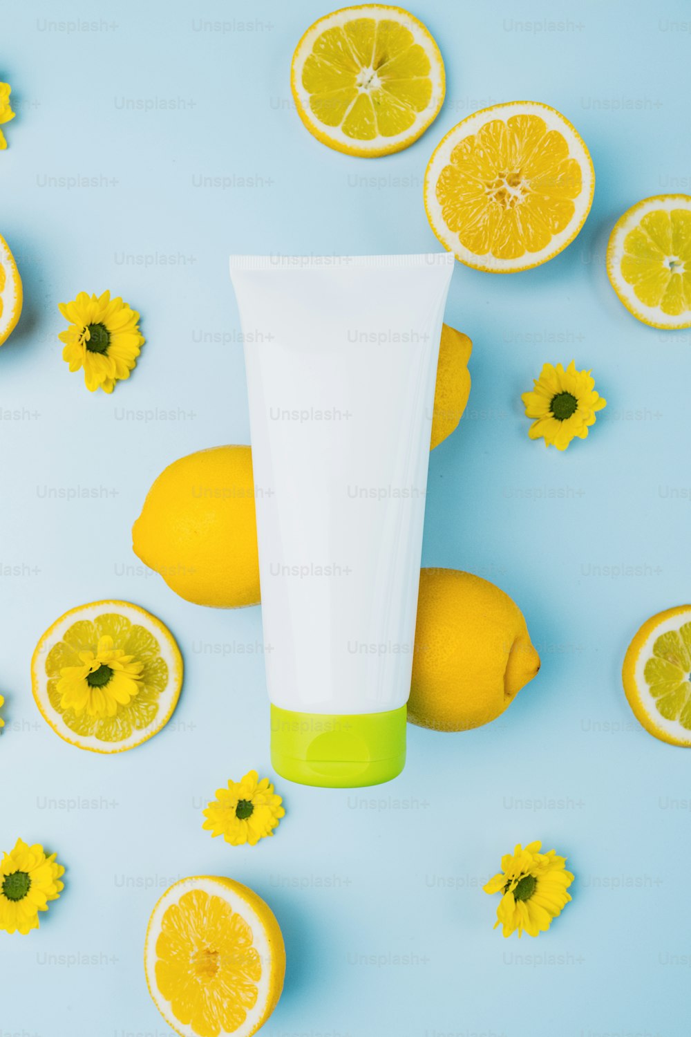 a tube of lotion surrounded by lemons and flowers