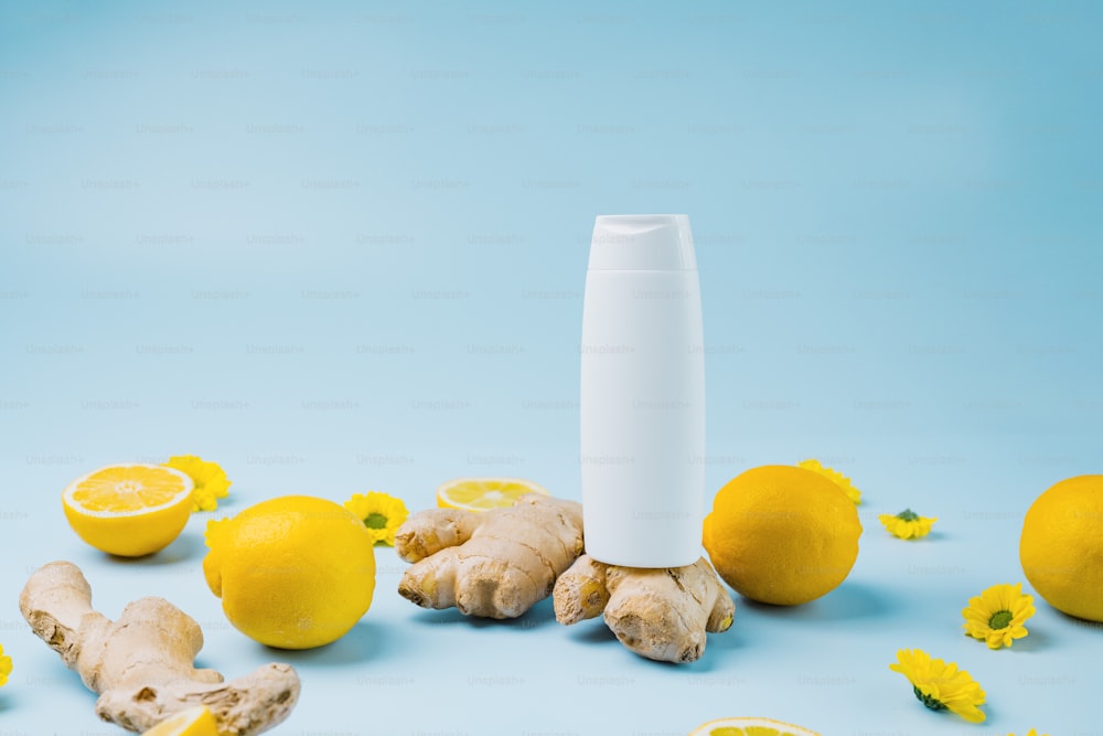 a white tube surrounded by lemons and ginger