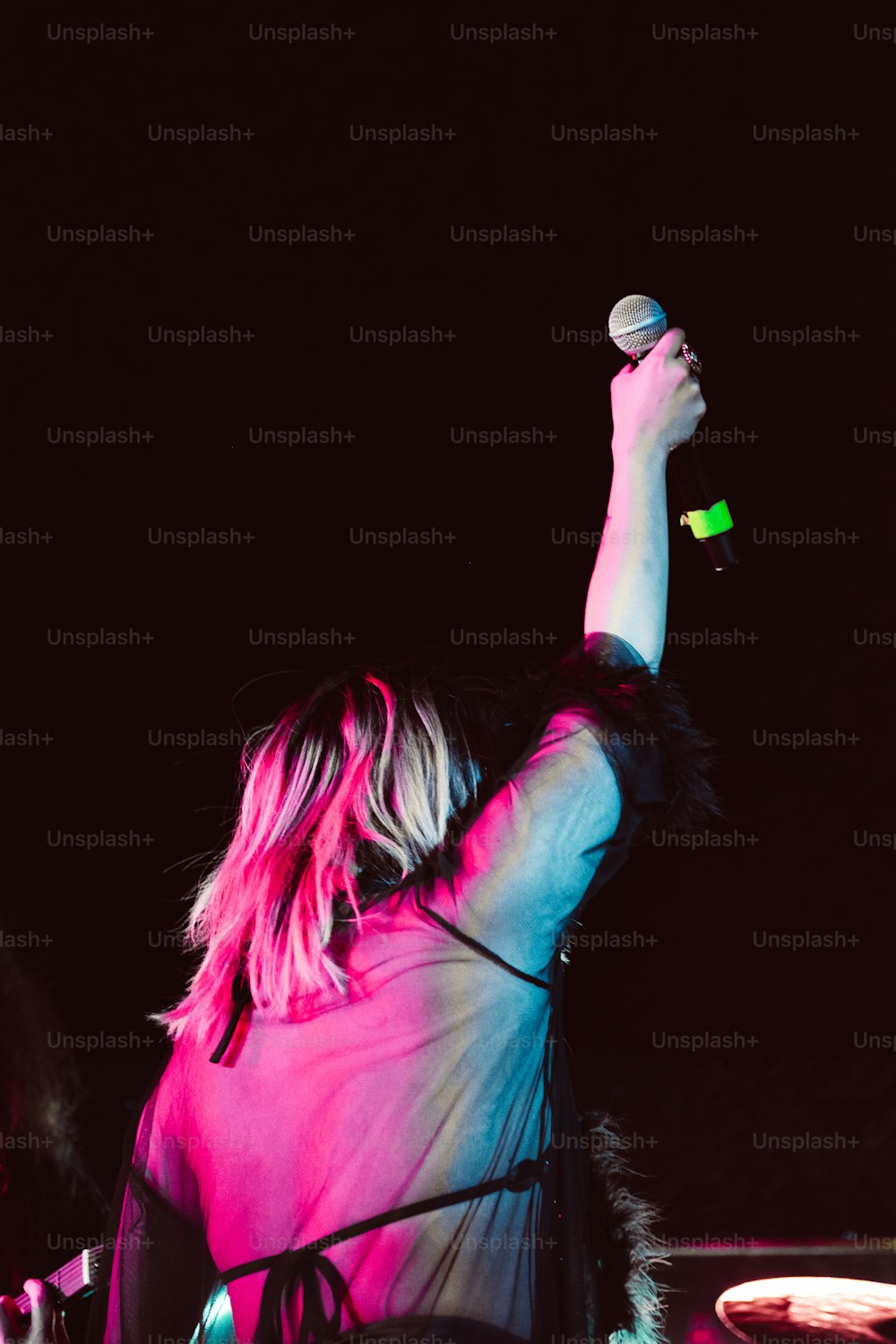 a woman holding a microphone up in the air