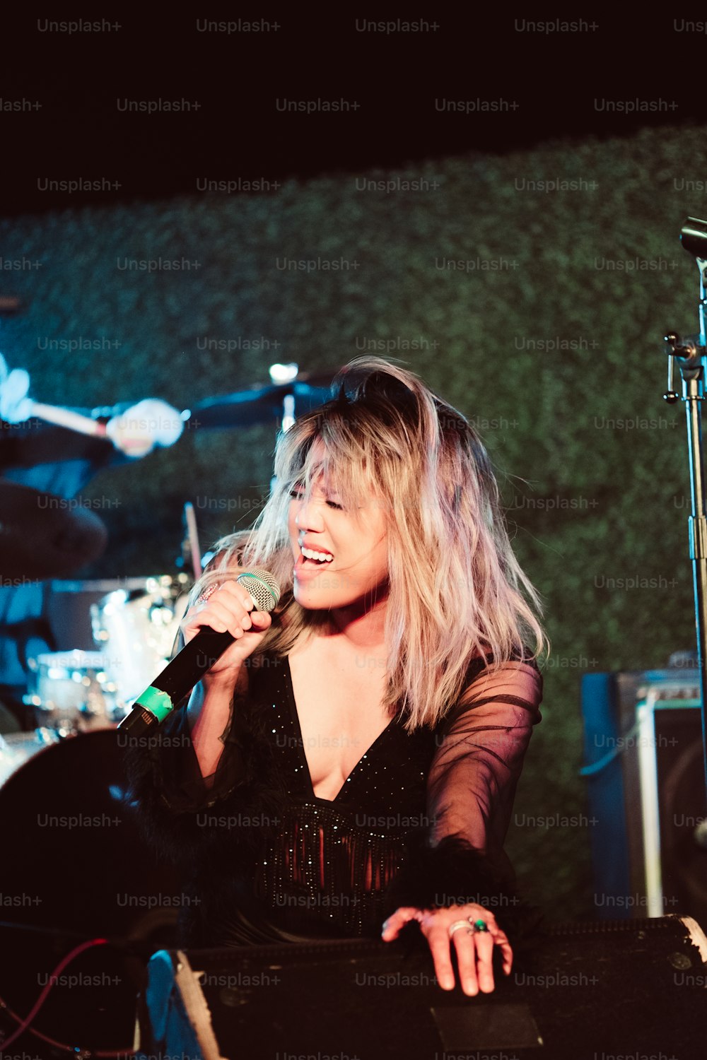 a woman singing into a microphone on stage