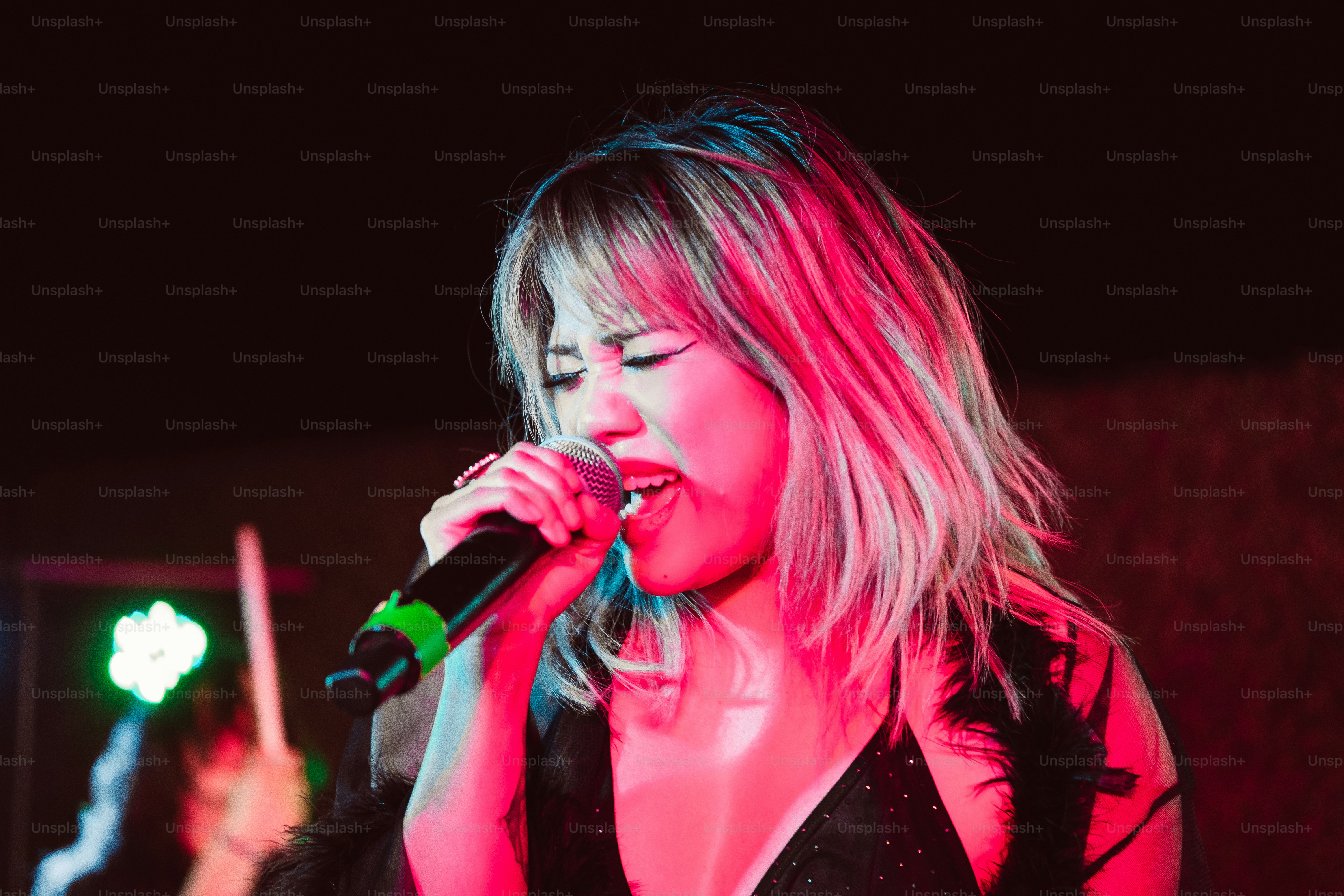 a woman singing into a microphone on stage