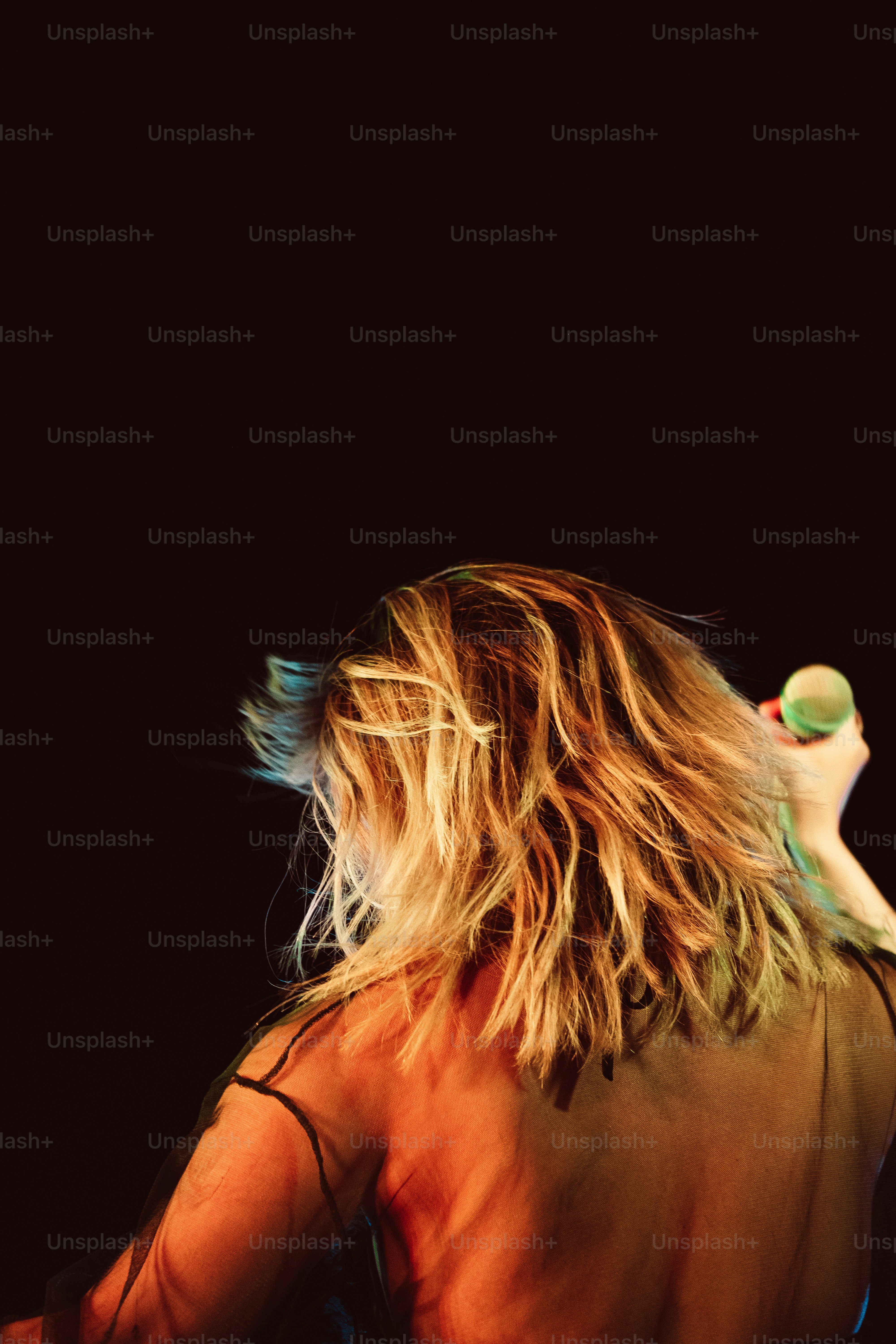 Una mujer con el pelo largo sostiene una tabla de surf