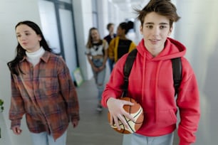 Junge Gymnasiasten, die in einem Korridor in der Schule gehen, Back-to-School-Konzept.