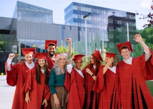 Eine Gruppe fröhlicher Universitätsstudenten mit Lehrer, die im Freien feiern, in die Kamera schauen, Abschlusskonzept.