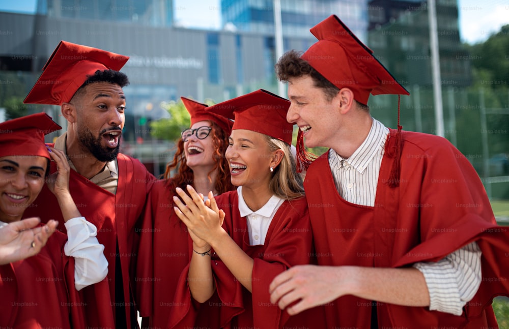 Eine Gruppe fröhlicher Universitätsstudenten feiert im Freien, Abschlusskonzept.