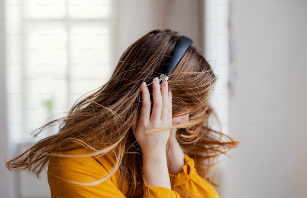 Uma jovem estudante feliz com fones de ouvido se divertindo.