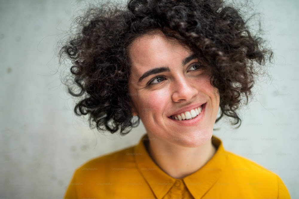 Um retrato de uma jovem estudante ou empresária em pé na sala em uma biblioteca ou escritório.