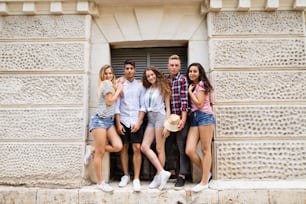 Grupo de atractivas estudiantes adolescentes posando frente a la universidad.