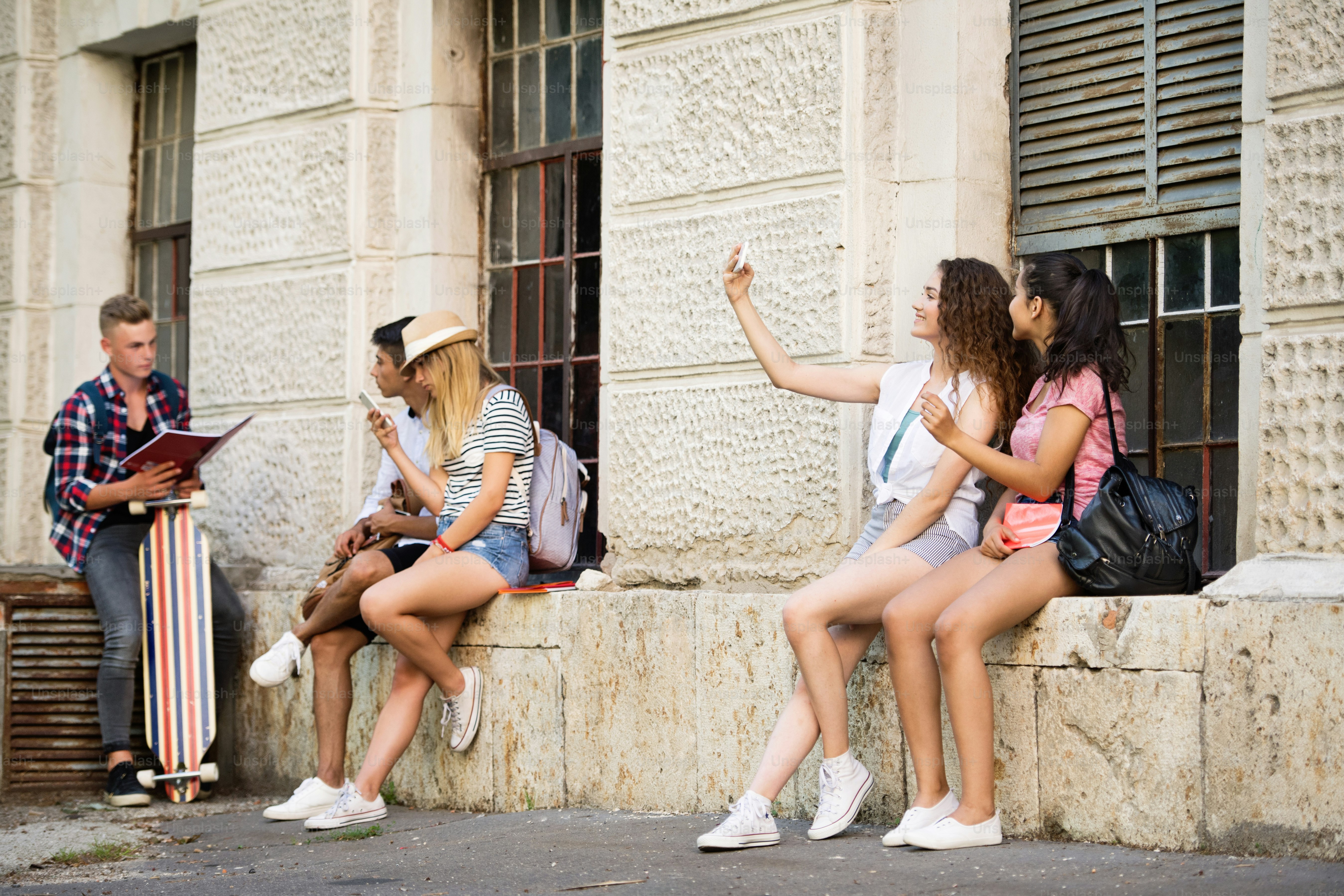 Group attractive teenage students talking in front of university.