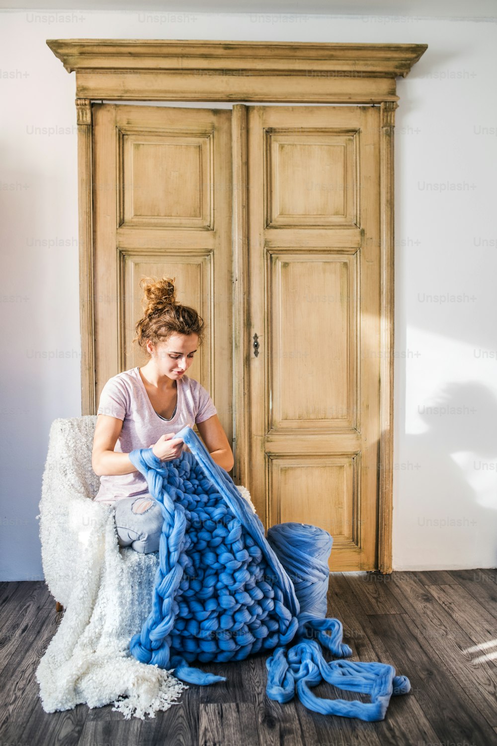 Small business of a young woman. Young woman hand-knitting a woollen blanket.