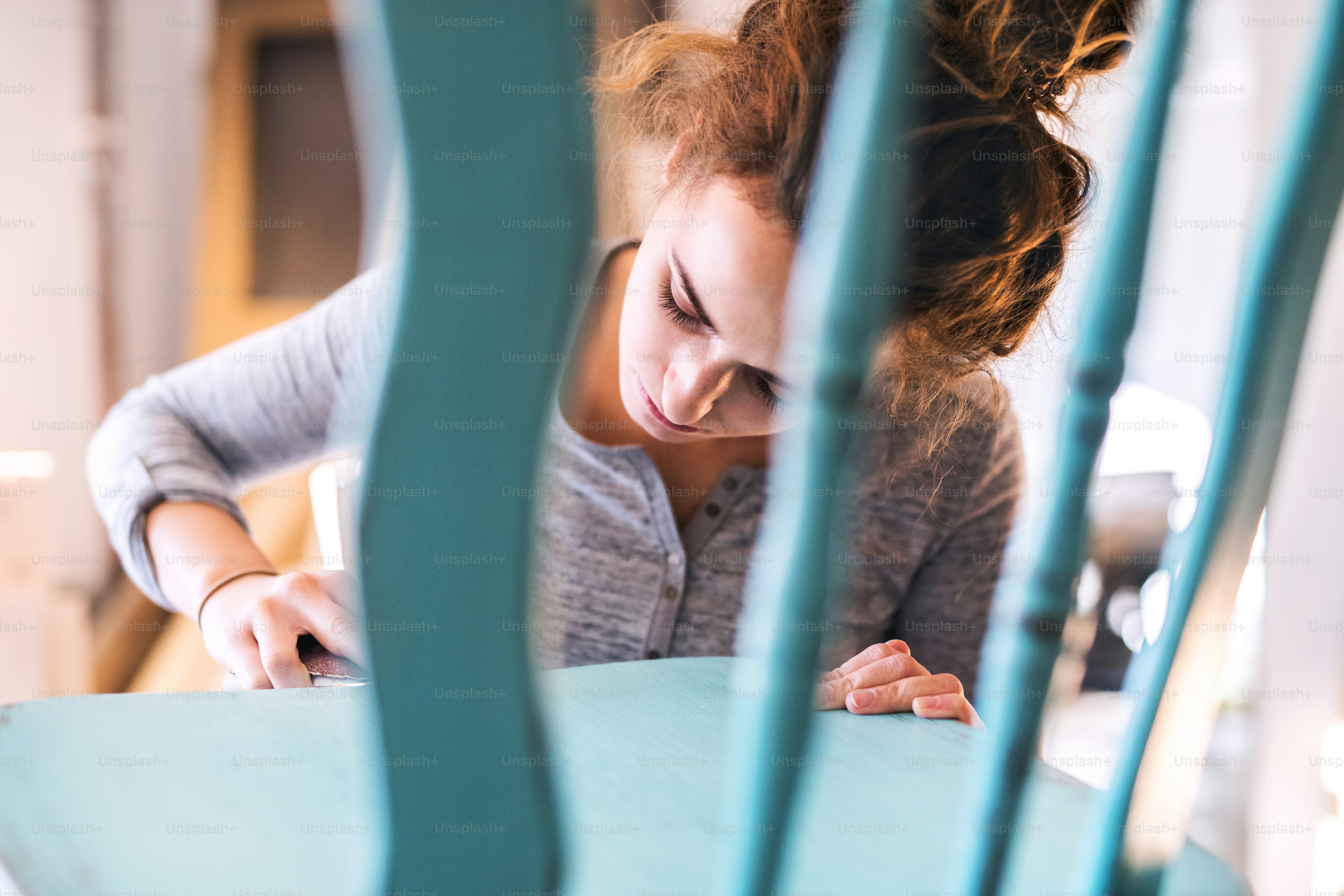 Kleines Geschäft einer jungen Frau. Schöne junge Arbeiterin im Zimmermannsarbeitsraum. Restaurierung alter Möbel.