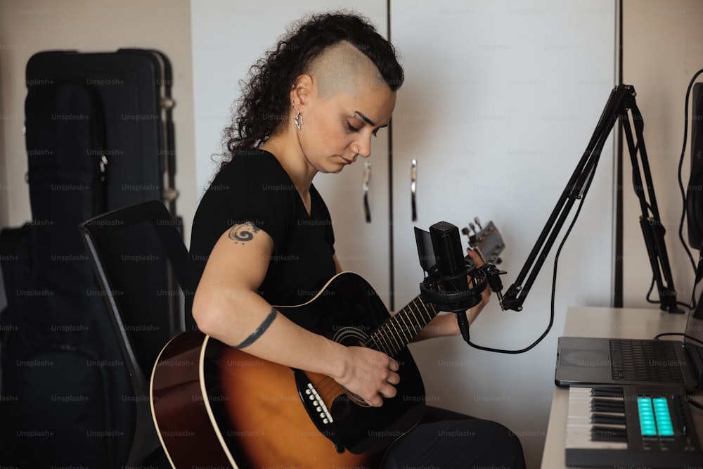 a woman with a shaved head playing a guitar