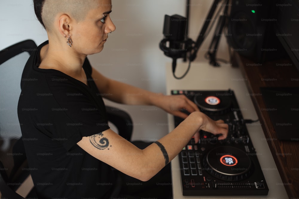 a woman sitting at a desk with a dj controller